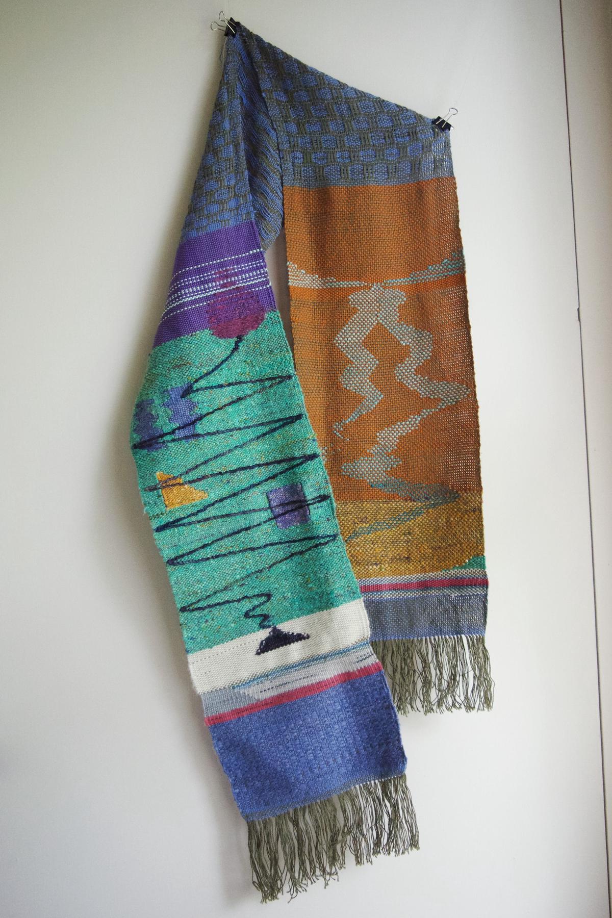 a figurative scarf hanging in front of a white wall